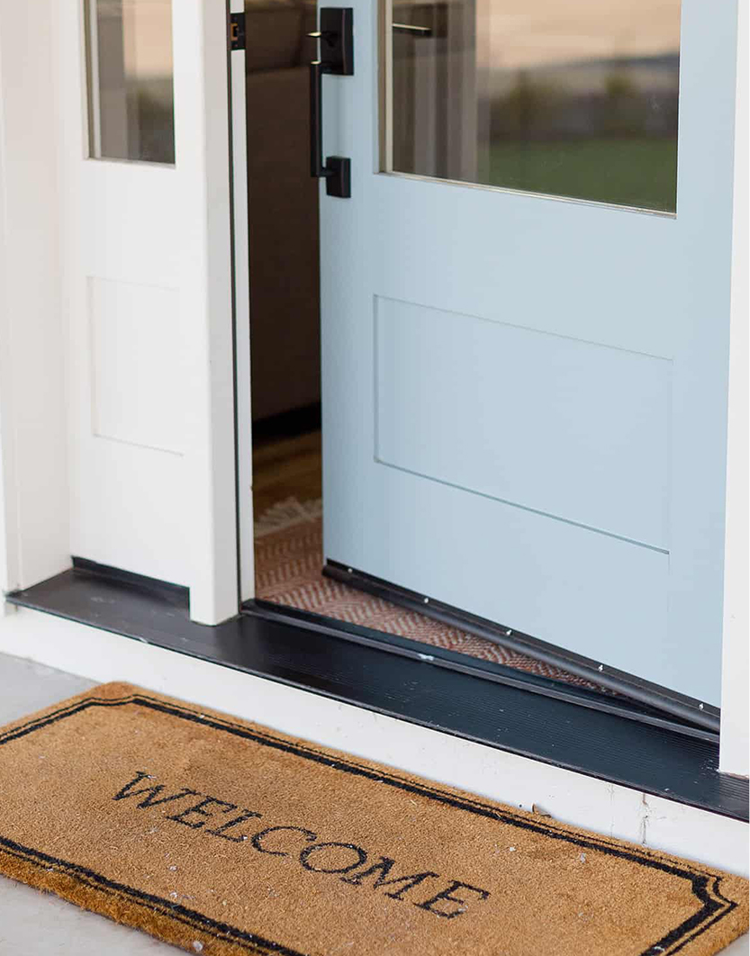 Blue door with welcome doormat