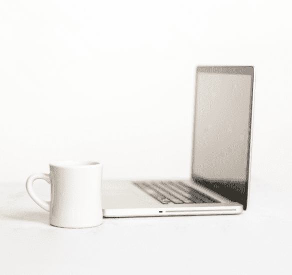 laptop and coffee cup on white table