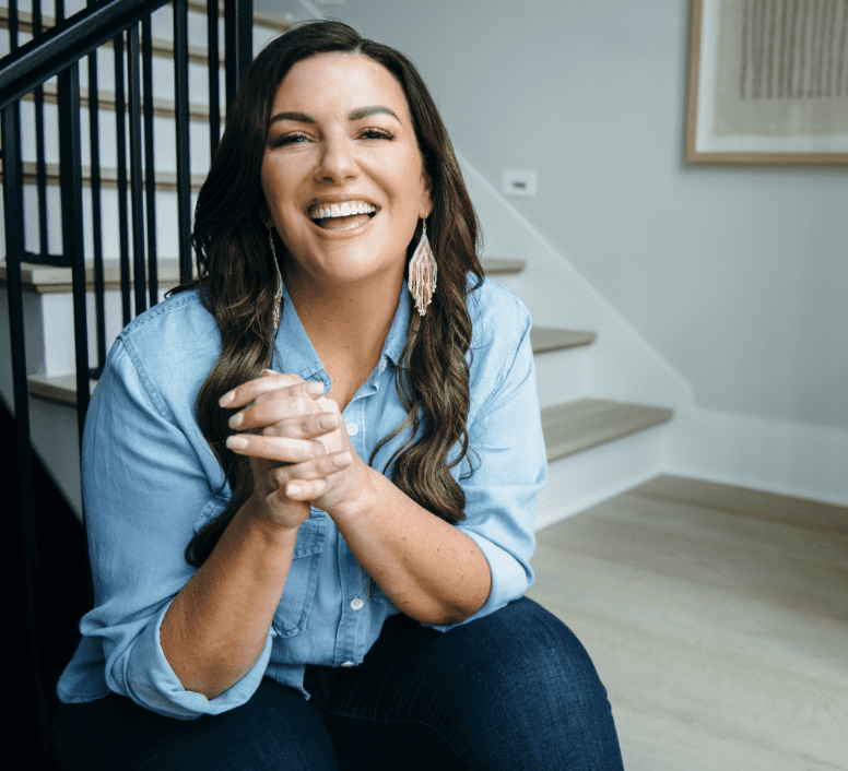 amy porterfield wearing blue shirt sitting by stairs