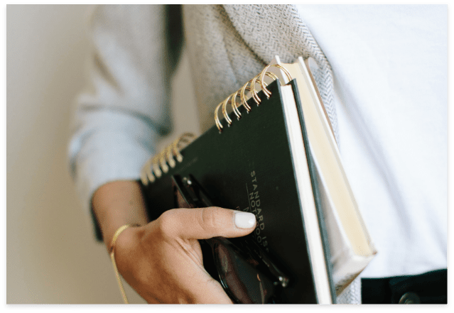 woman carrying a green planner